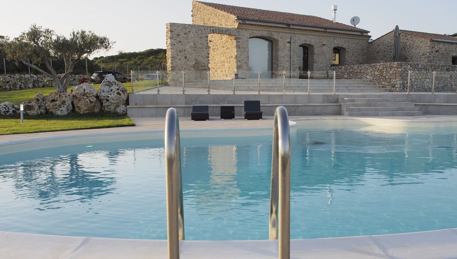 Scaletta della piscina e casale sullo sfondo